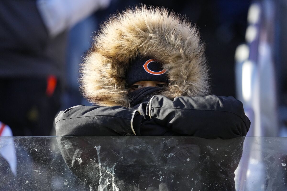 A bundled-up Chicago Bears fan watches from the stands