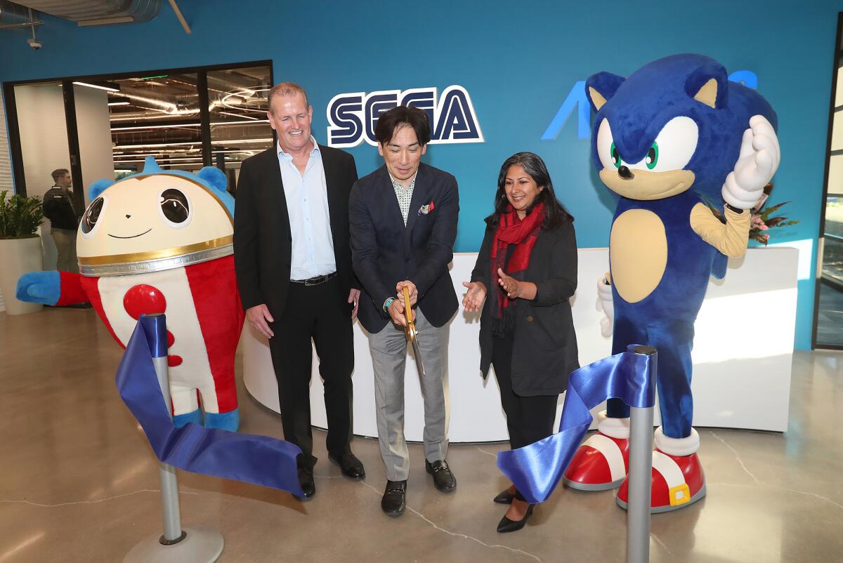 Ian Curran, Pres. Sega America, Shuji Utsumi, CEO of Sega America, Irvine mayor Farrah Khan, from left, at Sega in Irvine.