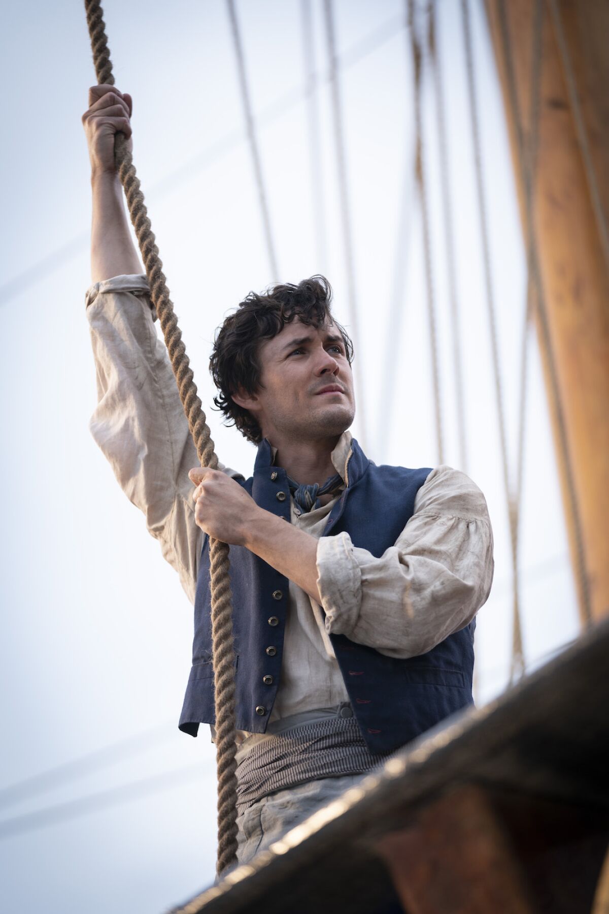 Jonah Hauer-King clings to ship's rigging in the movie "The Little Mermaid."