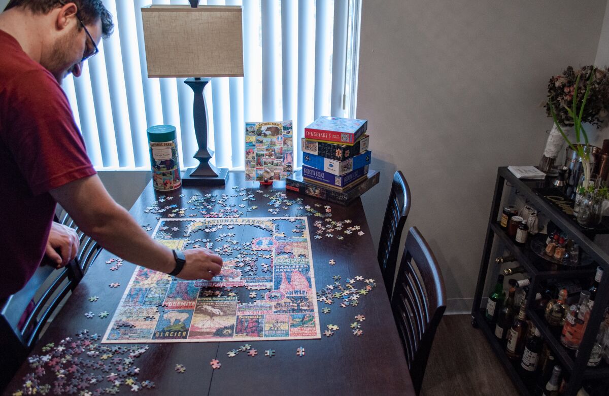 Jason Stump of La Mesa works on a puzzle to pass the time while sheltering at home.