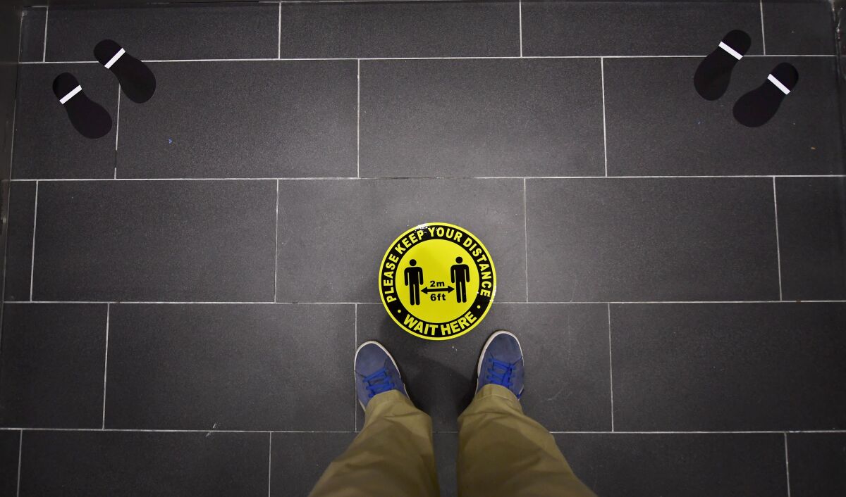 Foot markings and a coronavirus social distance reminder are seen on the floor of an elevator in office building.
