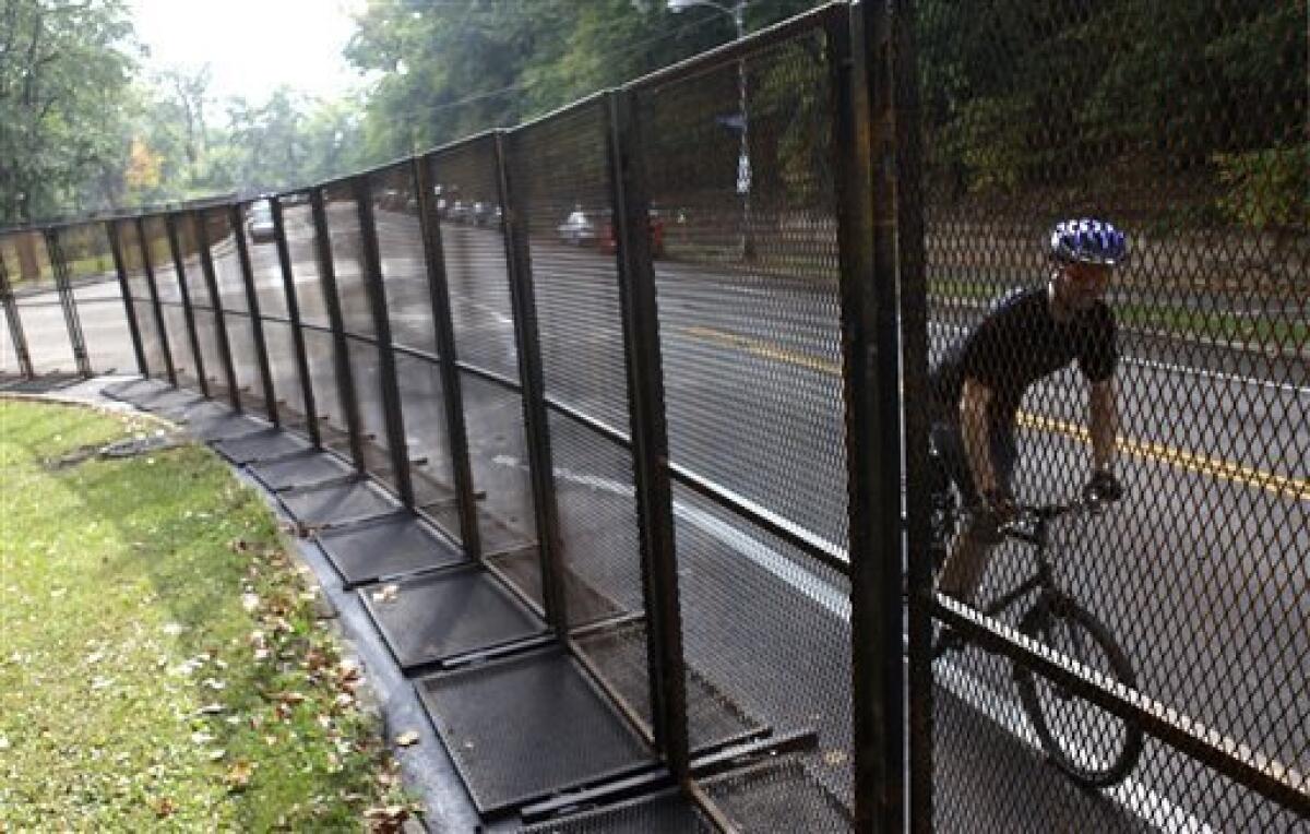 A cyclist rides alone tall steel barricades that line the perimeter of Schenley Park near the Phipps Conservatory & Botanical Gardens in preparation for the G-20 Summit in Pittsburgh, Tuesday, Sept. 22, 2009. Phipps Conservatory & Botanical Gardens is scheduled to be the site of the opening G-20 Summit reception and working dinner, Thursday, Sept. 24. The two-day G-20 Summit is scheduled to occur in Pittsburgh Sept. 24, and Sept. 25. (AP Photo/Carolyn Kaster)