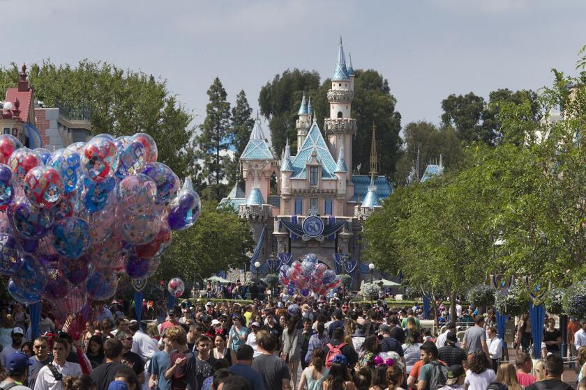 A large crowd strolls down Main Street, U.S.A., at Disneyland.
