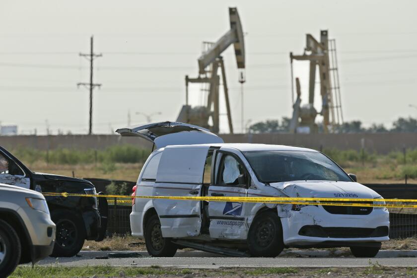 A U.S. Mail vehicle, right, which was involved in Saturday's shooting, is pictured outside the Cinergy entertainment center Sunday, Sept. 1, 2019, in Odessa, Texas. The death toll in the West Texas shooting rampage increased Sunday as authorities investigated why a man stopped by state troopers for failing to signal a left turn opened fire on them and fled, shooting over a dozen people as he drove before being killed by officers outside a movie theater. A police vehicle is partially blocked at left. (AP Photo/Sue Ogrocki)