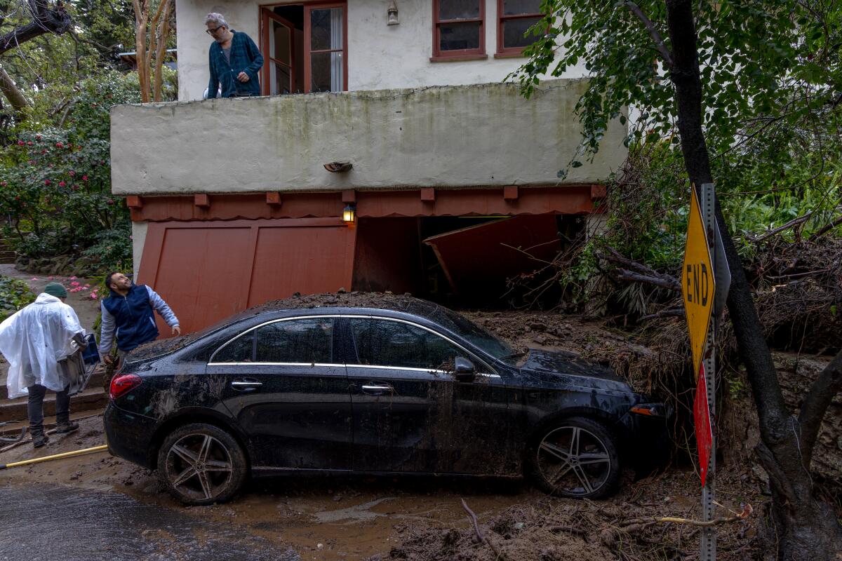 Mud and debris flow covers part of a parked car.