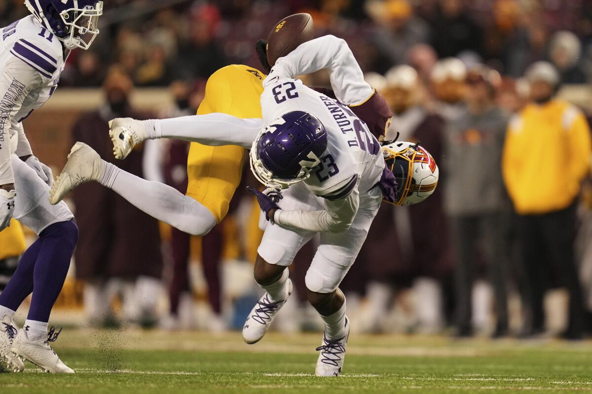 Minnesota wide receiver Dylan Wright (5) fumbles the ball after a hit by Northwestern defensive back Devin Turner (23) during the second half of an NCAA college football game Saturday, Nov. 12, 2022, in Minneapolis. (AP Photo/Abbie Parr)