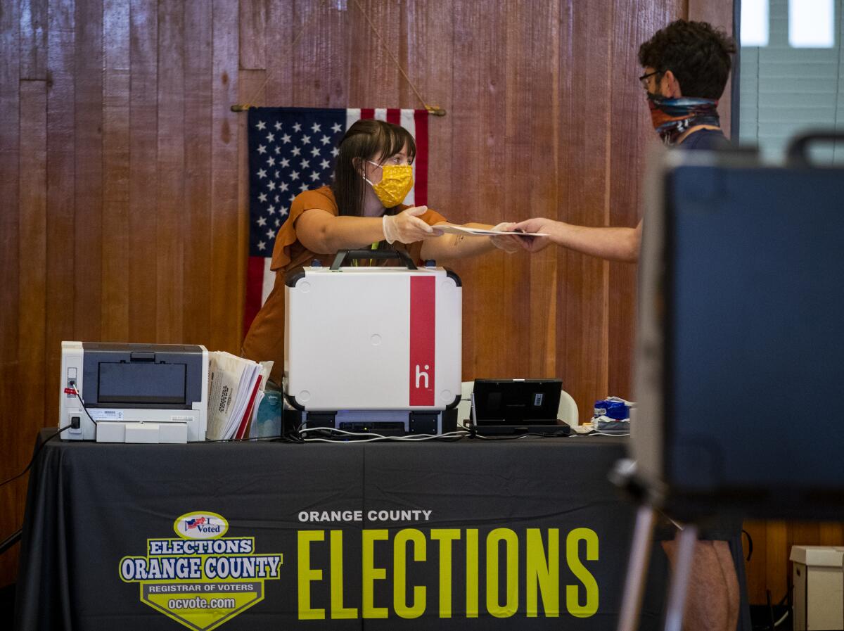 An election worker assists a voter at a Huntington Beach vote center on Tuesday