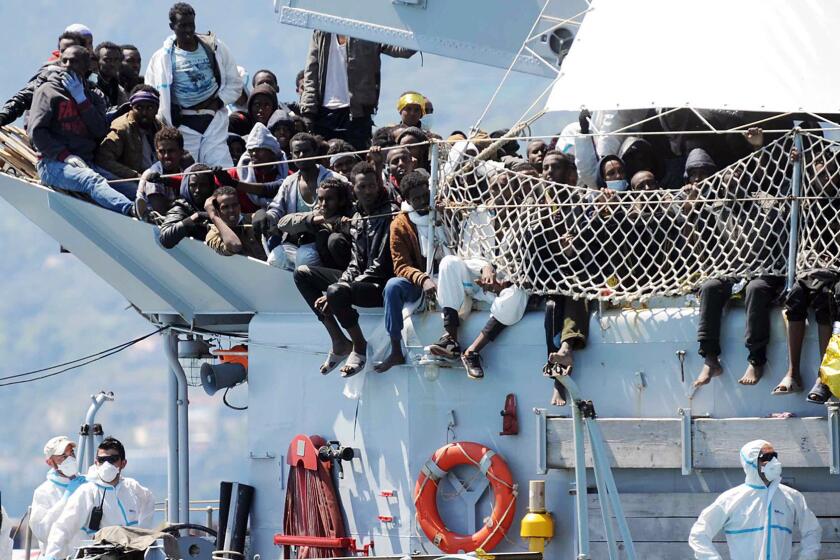 Migrants wait to disembark from the Italian navy vessel Chimera in the harbor of Salerno, Italy, Wednesday, April 22, 2015. Italy pressed the European Union on Wednesday to devise concrete, robust steps to stop the deadly tide of migrants on smugglers' boats in the Mediterranean, including setting up refugee camps in countries bordering Libya.
