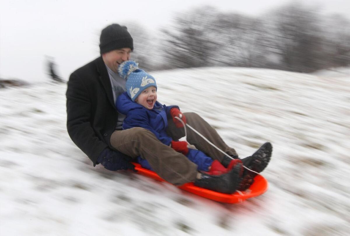 Mike Redmond and his 3-year-old son, Matt, ride a sled down a hill after an overnight snowfall in Baltimore in 2012.