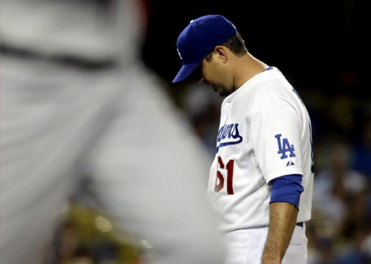 Dodgers pitcher Josh Beckett drops his head after walking Washington Nationals' Bryce Harper Monday night.