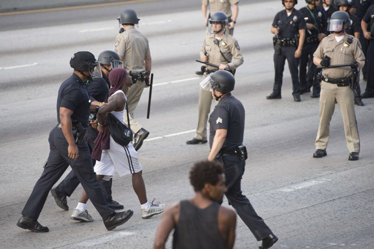 A protester is arrested on the 10 Freeway after demonstrators angry at the acquittal of George Zimmerman in the death of Trayvon Martin walk onto the freeway stopping highway traffic.