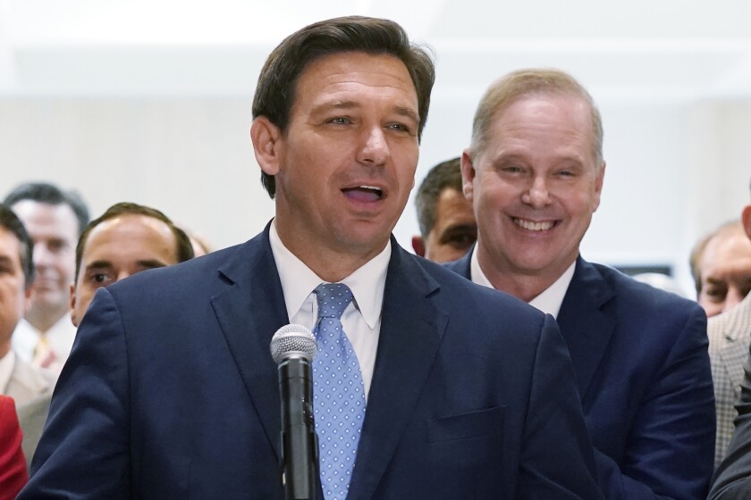 FILE - In this April 30, 2021, file photo surrounded by lawmakers, Florida Gov.Ron DeSantis speaks at the end of a legislative session at the Capitol in Tallahassee, Fla. Now that the pandemic appears to be waning and DeSantis is heading into his reelection campaign next year, he has emerged from the political uncertainty as one of the most prominent Republican governors and an early White House front-runner in 2024 among Donald Trump's acolytes, if the former president doesn't run again. (AP Photo/Wilfredo Lee, File)