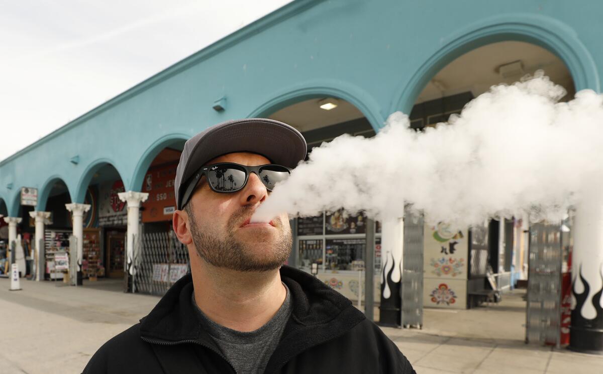 Marc Bury, visiting from Germany, vapes at the Venice Boardwalk.