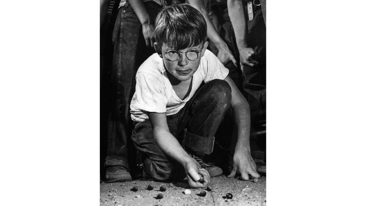 April 18, 1947: Charles Barker, 10, of Gates School, takes a bead in finals of city marble tournament at The Times Boys' Club. However, he lost to Victor Gonzales. This photo was published in the April 19, 1947, Los Angeles Times.