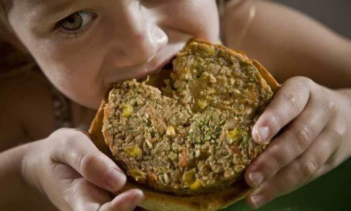 A child eats a garden burger from Whole Foods Market.