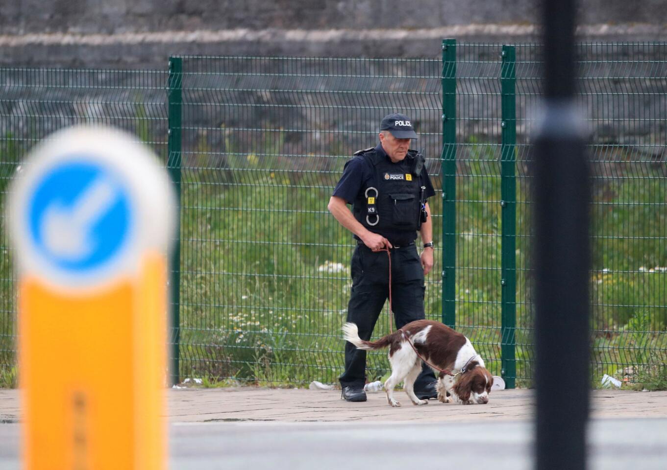 A police officer with a sniffer dog patrols near the Manchester Arena in Manchester, England, on May 23, 2017. An explosion struck an Ariana Grande concert attended by thousands of young music fans the previous night, killing 22 people.