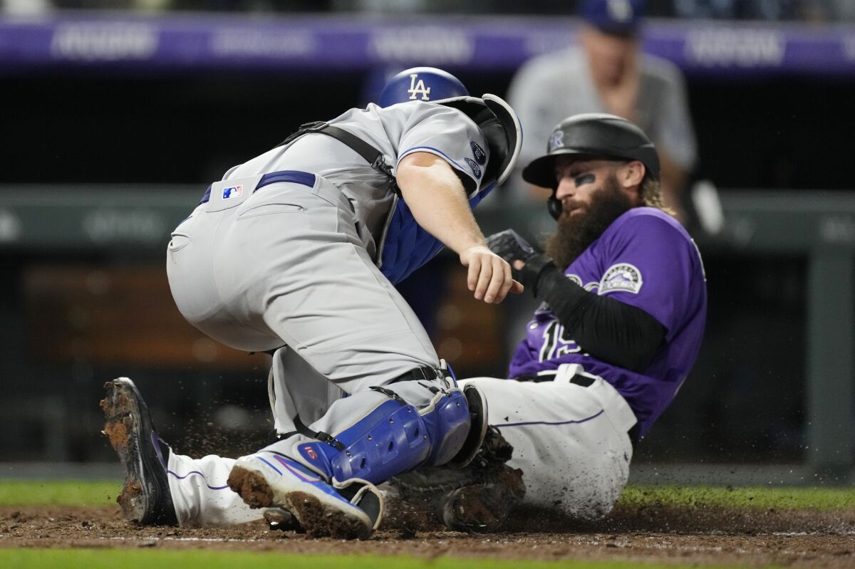 Dodgers catcher Will Smith applies a late tag as Colorado Rockies' Charlie Blackmon scores on a double hit by C.J. Cron.