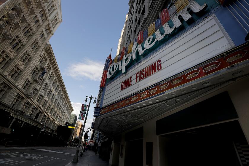 LOS ANGELES, CALIF. -MAR. 26, 2020. Words on the Orpheum theater marquee try to bring levity to the current situation along the normally bustling commercial area on Broadway in downtown Los Angeles, which is largely deserted because of the coronavirus lockdown. . (Luis Sinco/Los Angeles Times)