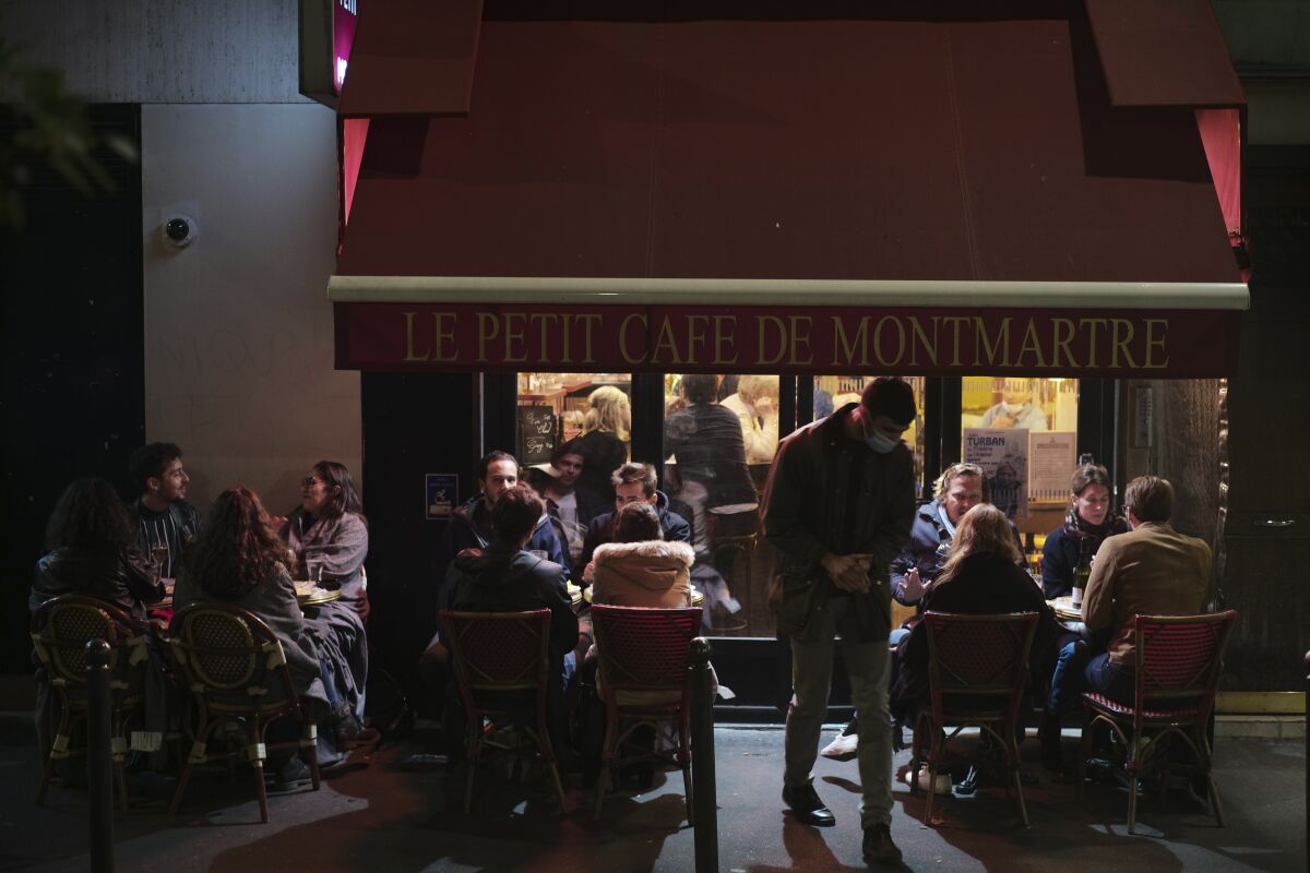 People enjoy a drink in a Paris cafe Sept. 26, 2020.