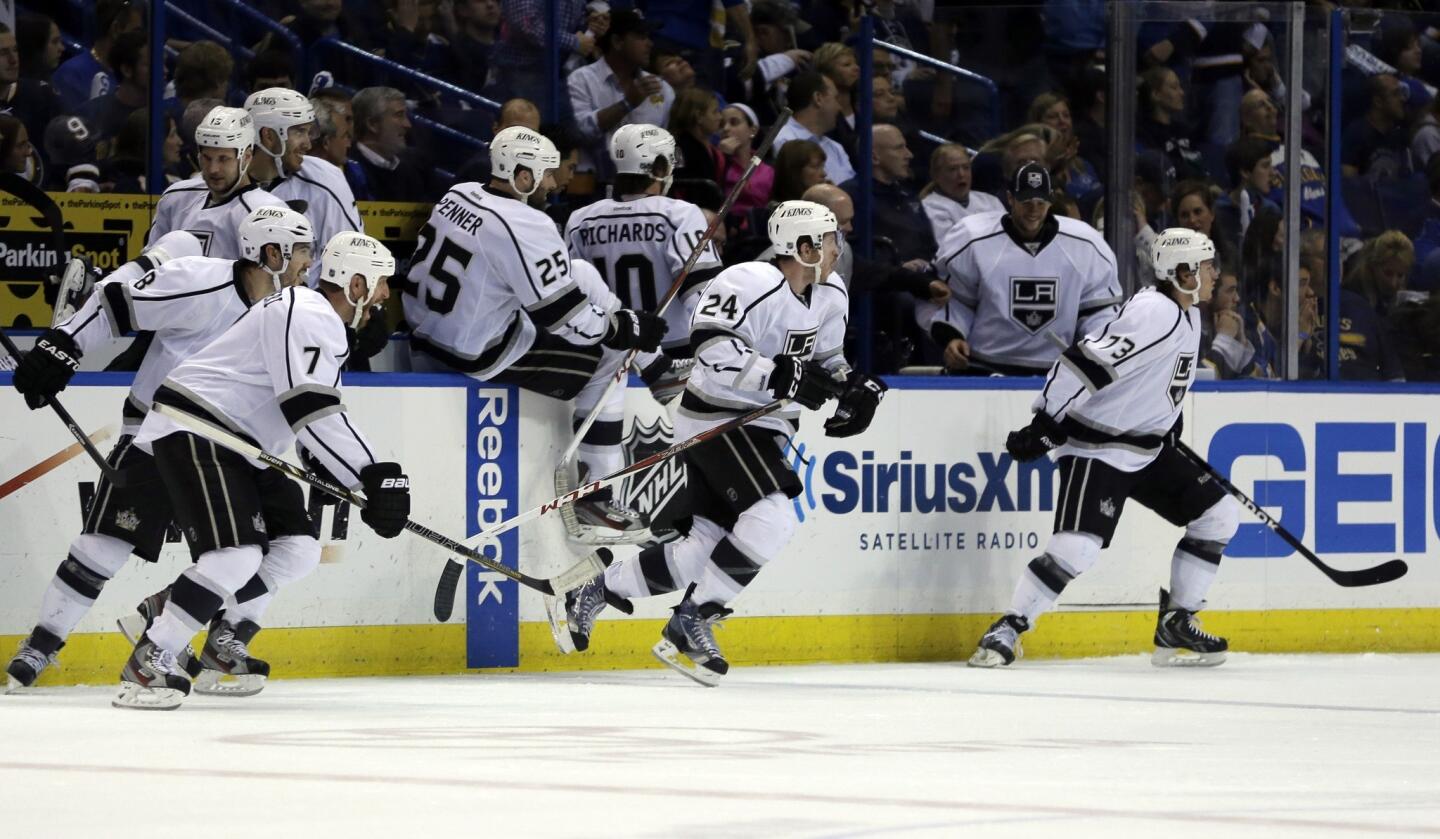 Los Angeles Kings players rush off the bench to congratulate teammate Slava Voynov after his game-winning goal during overtime.