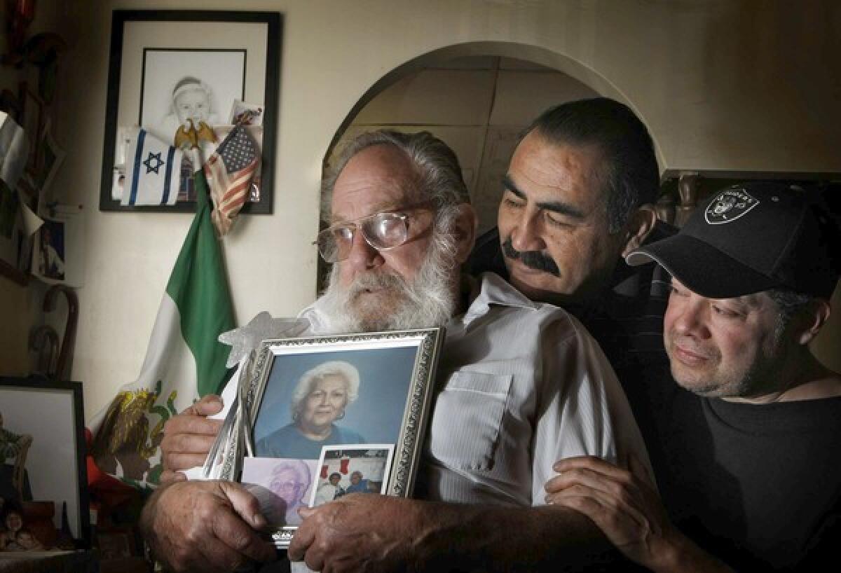 Eddie Goldstein holds a photo of his late wife, Esther. They were married 50 years and raised their kids, including Art Perez, center, and Steven Goldstein, on Folsom Street.