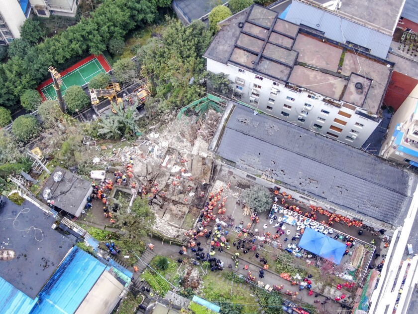 In this photo released by China's Xinhua News Agency, emergency officials work at the site of an explosion in southwestern China's Chongqing municipality, Friday, Jan. 7, 2022. A lunchtime explosion at a cafeteria killed more than a dozen people in southwest China on Friday, authorities said. A gas leak is the suspected cause, the Chongqing city government said in an online statement. (Huang Wei/Xinhua via AP)