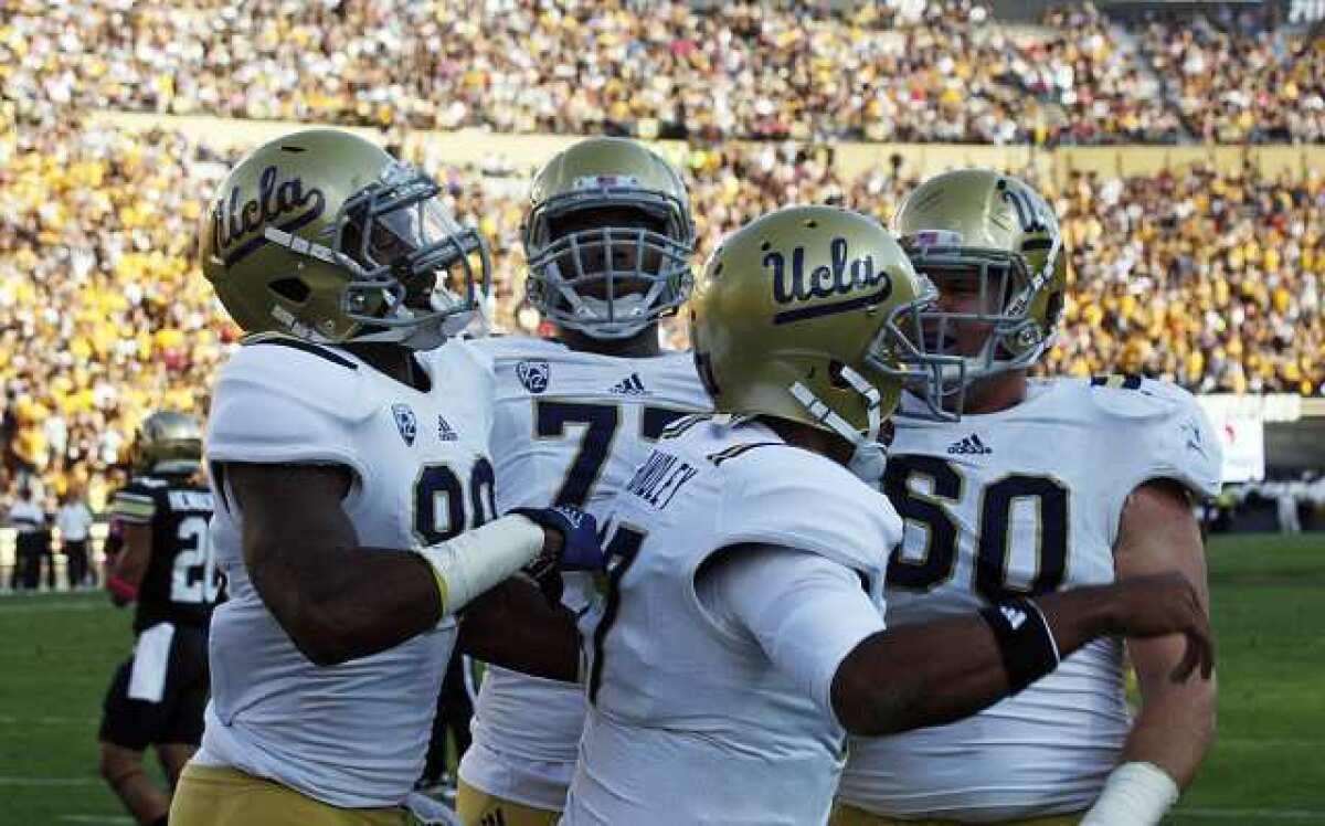 Bruins Jerry Rice Jr., left, Torian White and Jeff Baca celebrate a touchdown run by quarterback Brett Hundley, foreground, against Colorado.