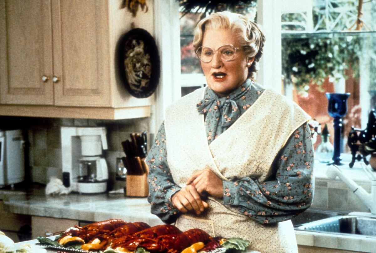 Robin William wears a wig, glasses, an apron and gray dress in "Mrs. Doubtfire"