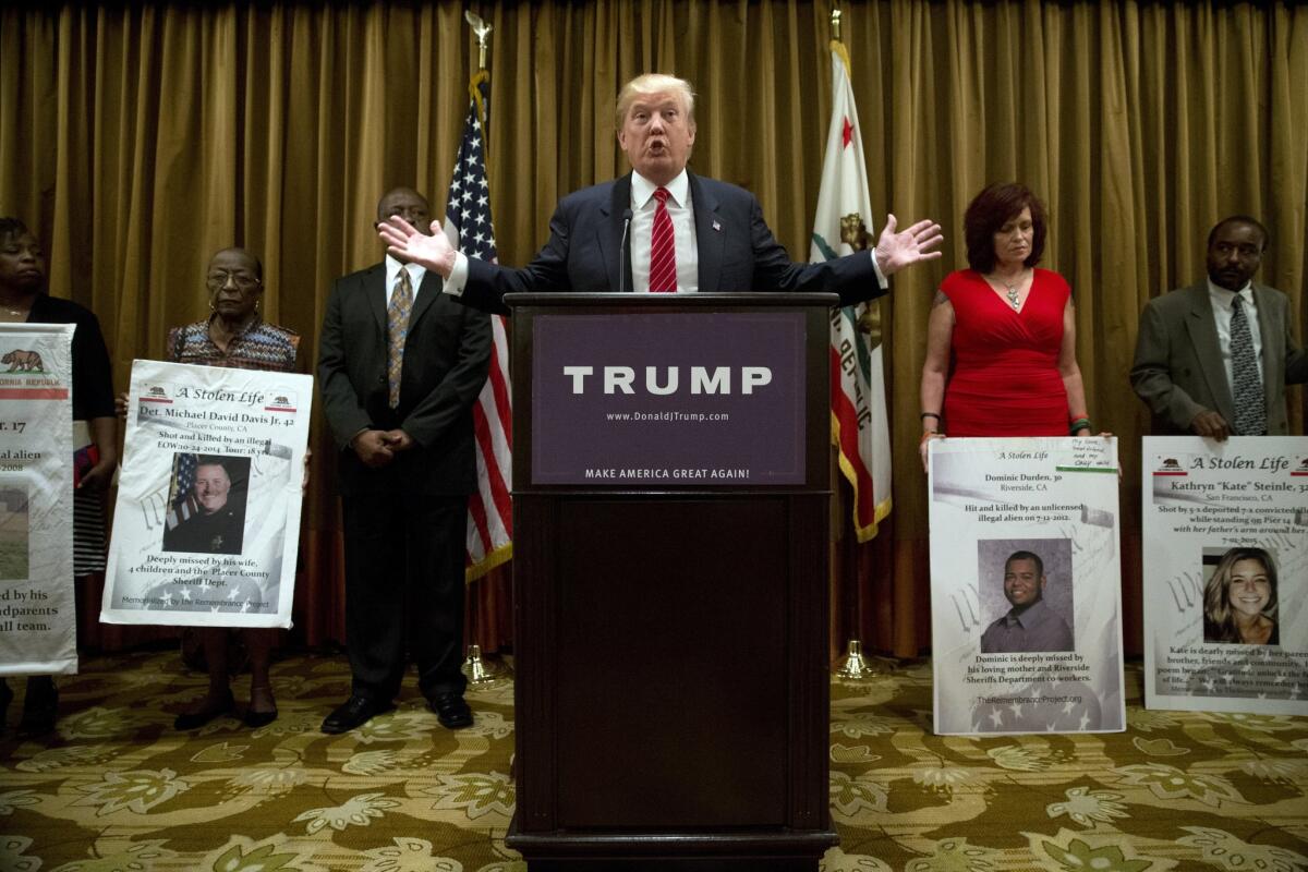 Republican presidential candidate Donald Trump, center, speaks at a news conference as he is joined by individuals who identify themselves as family members of victims who were killed, Friday, July 10, 2015, in Beverly Hills, Calif. Trump also discussed immigration during the news conference. (AP Photo/Jae C. Hong)