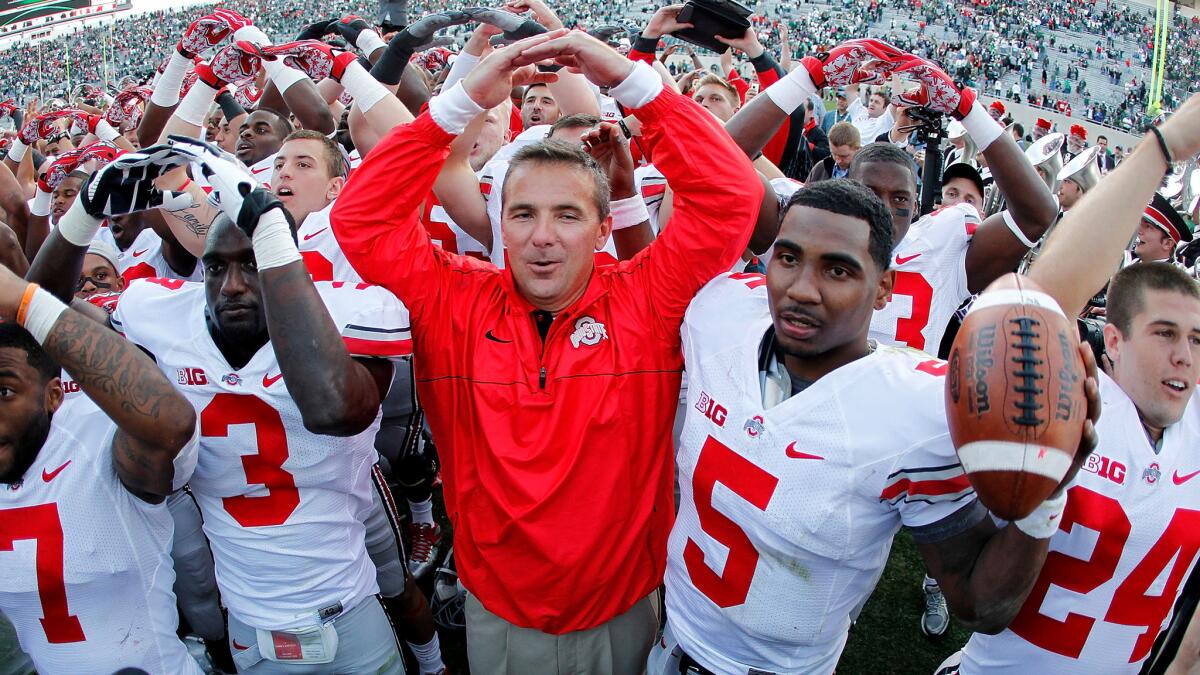 Ohio State Coach Urban Meyer celebrates with his players aftera a 17-16 victory over Michigan State last season.