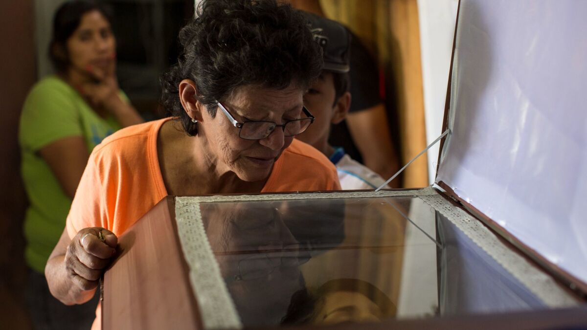 Yolanda Barahona looks into the coffin containing the body of her granddaughter Kimberly Dayana Fonseca, 19, in Tegucigalpa, Honduras, on Saturday. Fonseca was shot to death at a protest supporting opposition presidential candidate Salvador Nasralla.