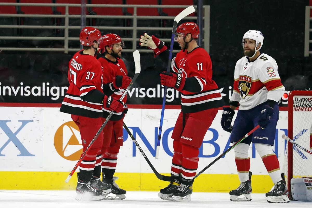 Carolina Hurricanes' Vincent Trocheck (16), center, is congratulated on his goal by teammates Jordan Staal (11) and Andrei Svechnikov (37) with Florida Panthers' Aaron Ekblad (5) nearby during the first period of an NHL hockey game in Raleigh, N.C., Sunday, March 7, 2021. (AP Photo/Karl B DeBlaker)