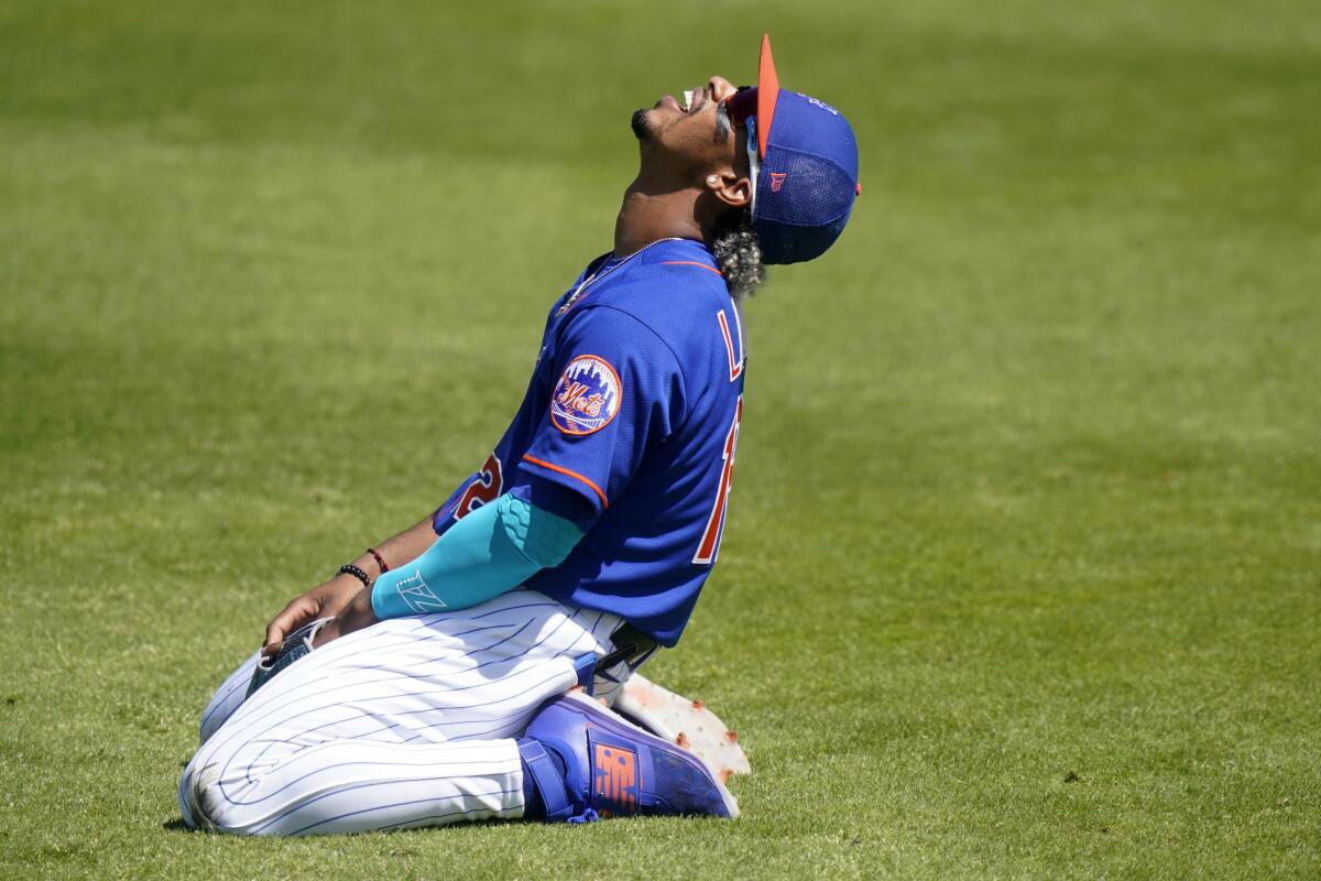 New York Mets shortstop Francisco Lindor reacts after he can't get to a ball hit for a single by St. Louis Cardinals' Yadier Molina during the third inning of a spring training baseball game, Sunday, March 14, 2021, in Port St. Lucie, Fla. (AP Photo/Lynne Sladky)