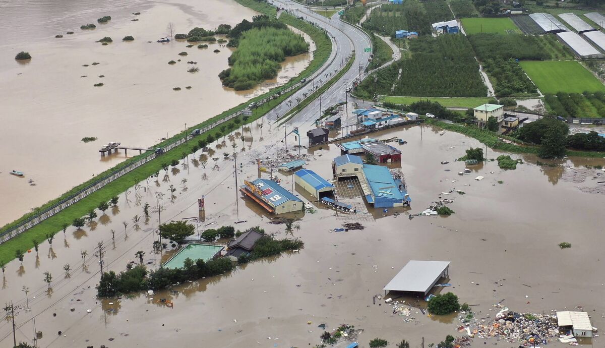 A village area is flooded near Seomjin River, left, due to heavy rain in Hadong, South Korea, Saturday, Aug. 8, 2020. (Kim Dong-min/Yonhap via AP)