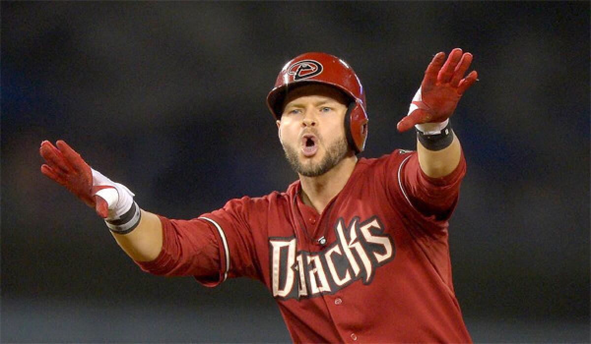 Cody Ross gestures to the Diamondbacks dugout after scoring the go-ahead run in the 12th inning of Arizona's 8-6 extra inning victory over the Dodgers on Wednesday.