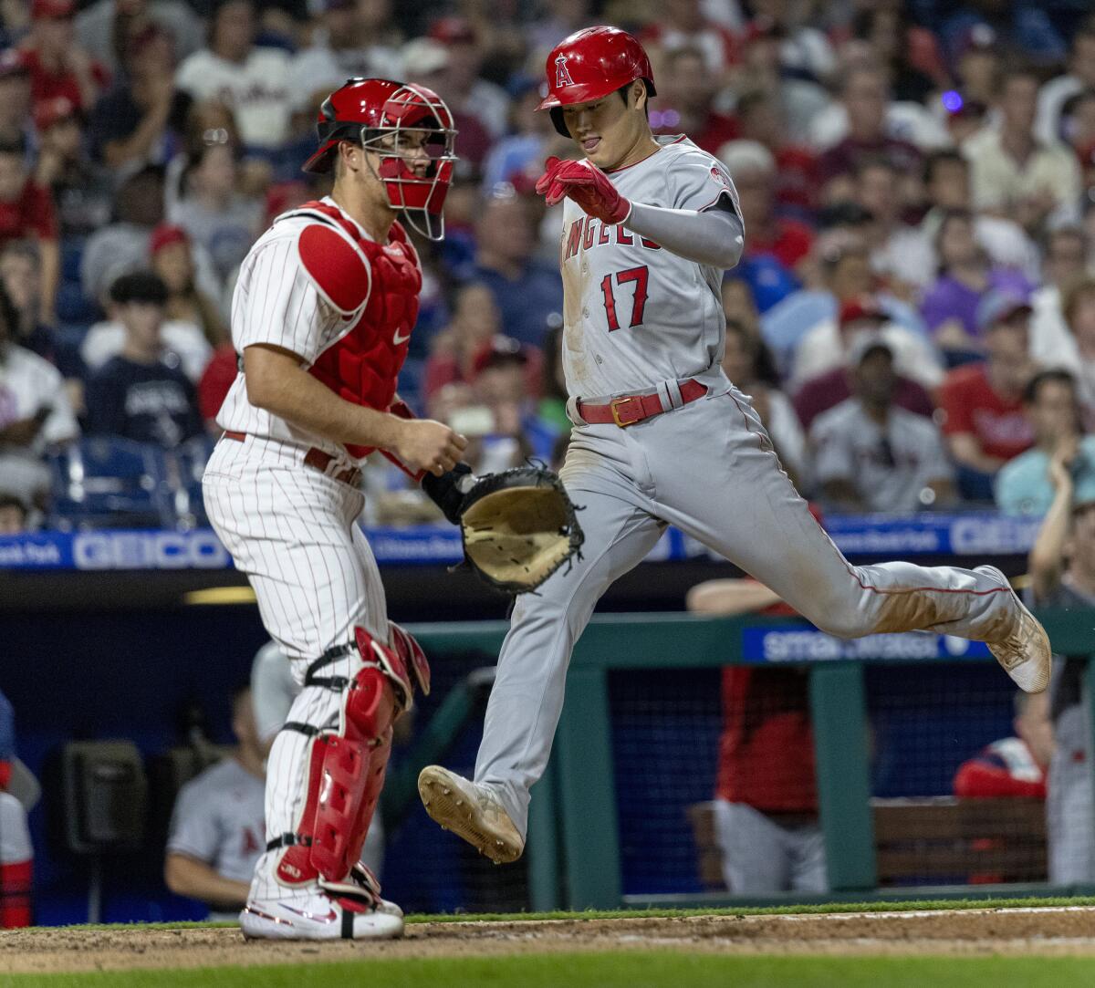 The Angels' Shohei Ohtani scores past Phillies catcher J.T. Realmuto on Jared Walsh's fifth-inning RBI double June 4, 2022.