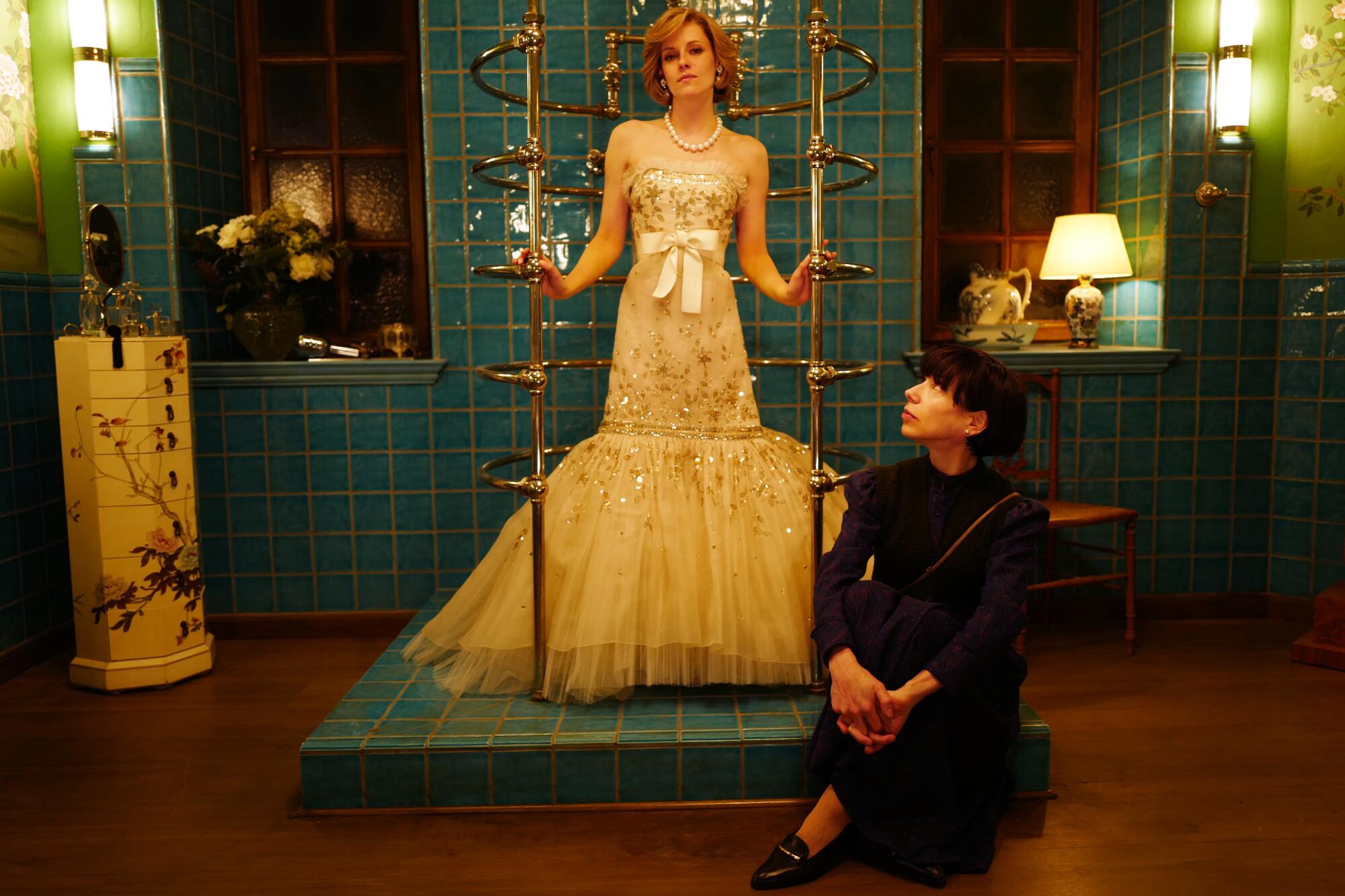Kristen Stewart wears a gown with pearls as Princess Diana in “Spencer" with Sally Hawkins as Maggie.