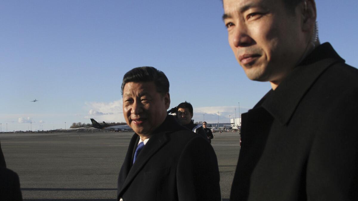 Chinese President Xi Jinping, left, smiles after getting off his plane for a refueling stop in Anchorage, Alaska on April 7, 2017.