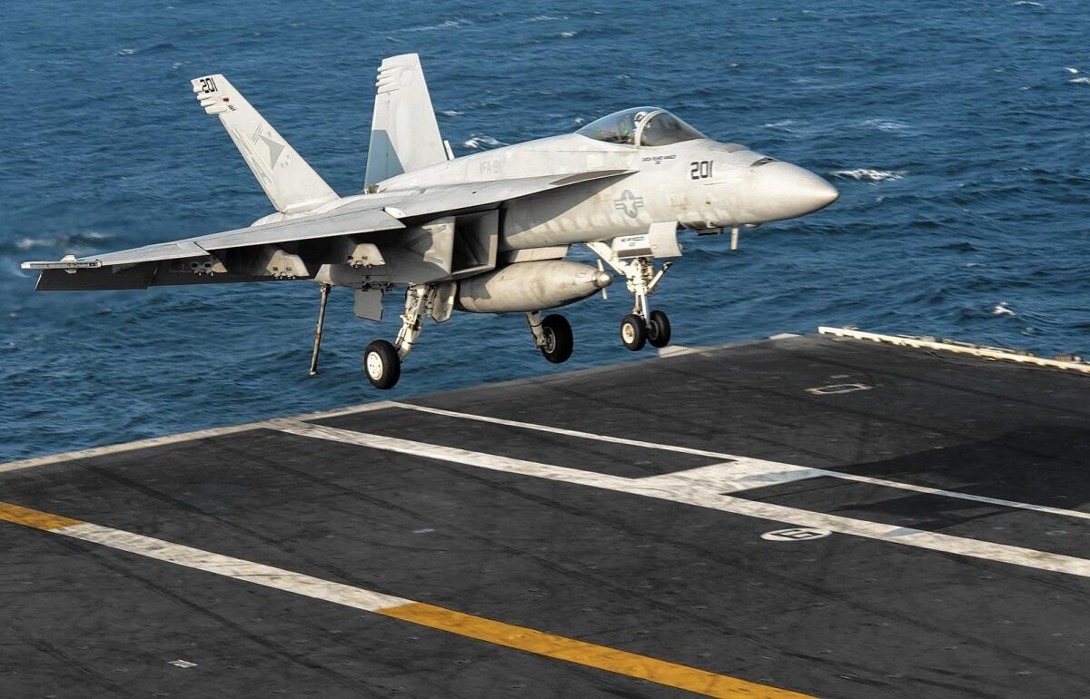 An F-18 lands on the flight deck of the aircraft carrier USS Carl Vinson in the Persian Gulf, part of operations targeting Islamic State militants in Iraq and Syria.