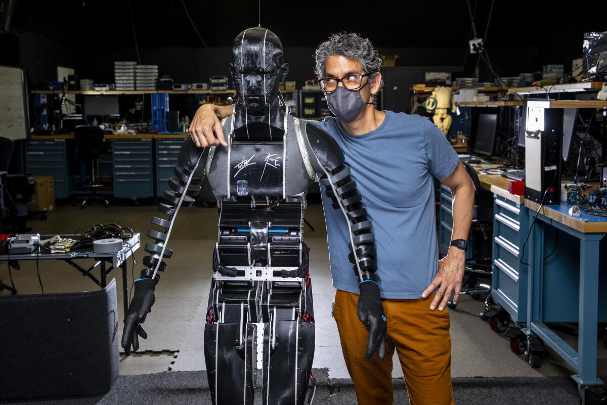 Tony Dohi, principal research and development Imagineer, poses with an early MkI prototype of the Stuntronics robot