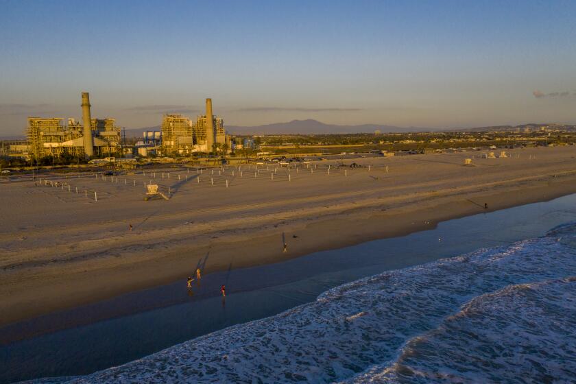 HUNTINGTON BEACH, CA - February 17: A view of the older AES Huntington Beach Power Station at left, and new one at right, and is the proposed site of the Poseidon Desalination Plant, which would draw ocean water through an existing intake pipe at Wednesday, Feb. 17, 2021 in Huntington Beach, CA. (Allen J. Schaben / Los Angeles Times)