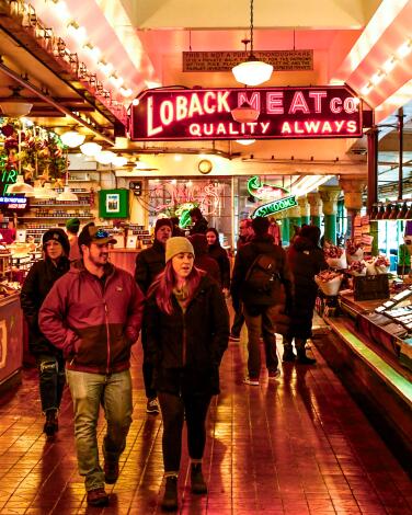 People walk among market stalls at Pike Place Market.