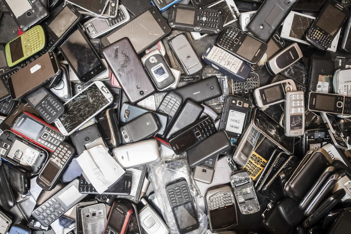 Discarded cellphones fill a bin at the Out of Use company warehouse in Beringen, Belgium.