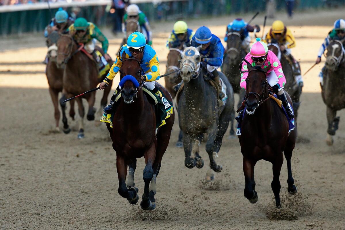 Jockey Victory Espinoza guides American Pharoah to the finish line ahead of Firing Line, right, and Dortmund, center, in the 141st Kentucky Derby.