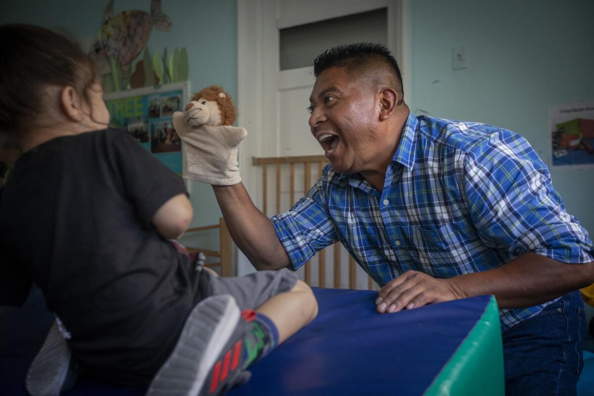 A boy interacts with teacher Ricky Gonzalez at the Atwater Park Center