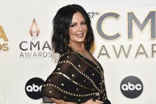 Sara Evans, in black and gold gown, at the 57th Annual CMA Awards in Nashville, Tenn. 