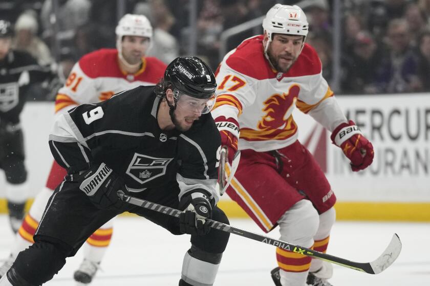 Los Angeles Kings right wing Adrian Kempe (9) controls the puck against Calgary Flames left wing Milan Lucic.