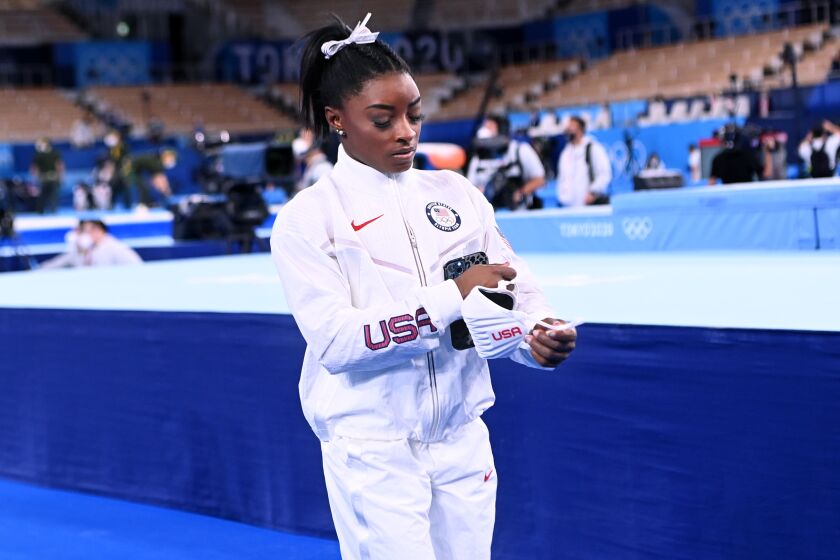 Simone Biles walks alone after the women's team final at the Tokyo Olympics.