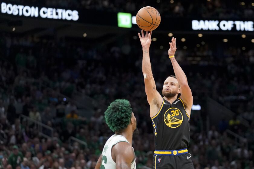 Golden State Warriors guard Stephen Curry (30) puts up a shot against Boston Celtics guard Marcus Smart (36) during the third quarter of Game 3 of basketball's NBA Finals, Wednesday, June 8, 2022, in Boston. (AP Photo/Steven Senne)