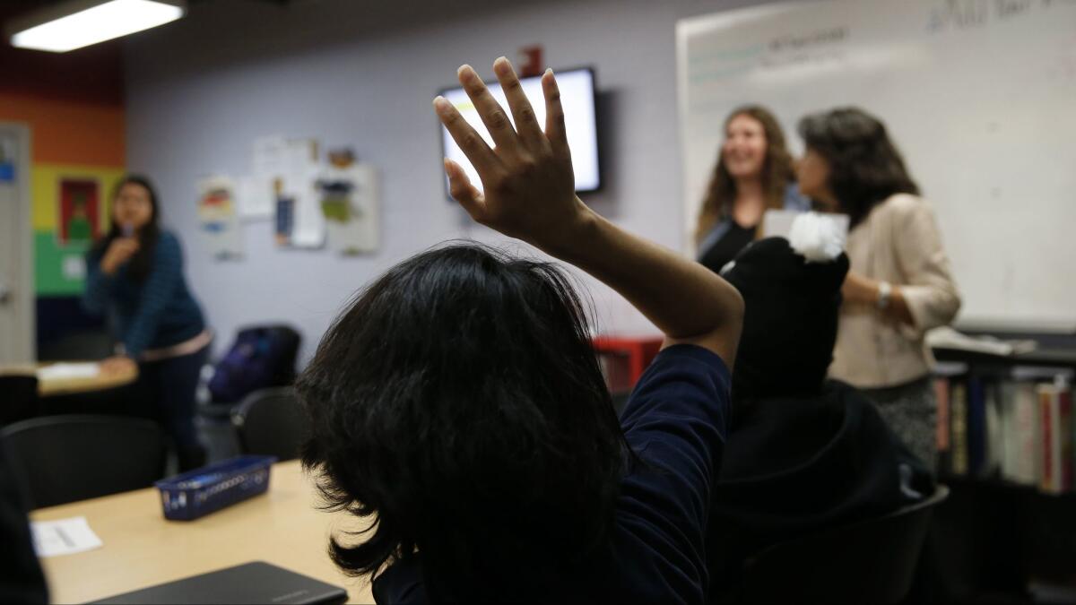 Cesar, un estudiante de preparatoria indocumentado, levanta la mano durante una clase de preparación universitaria en Kid City, en el South Park Neighborhood Center de Los Ángeles.